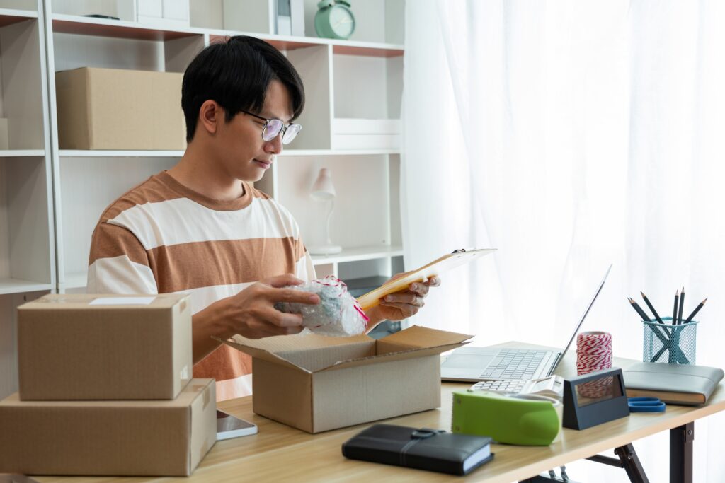 the salesperson reading the product list while packing the product into the box.