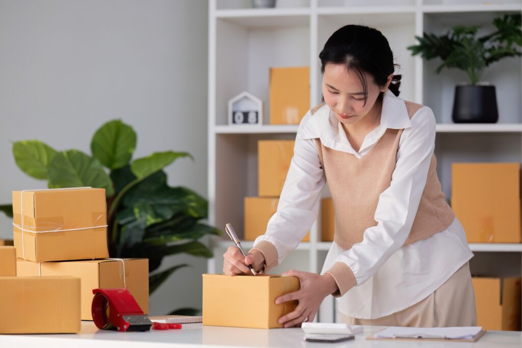 SME business entrepreneurs small in asia Writing shipping information on a cardboard box in my home